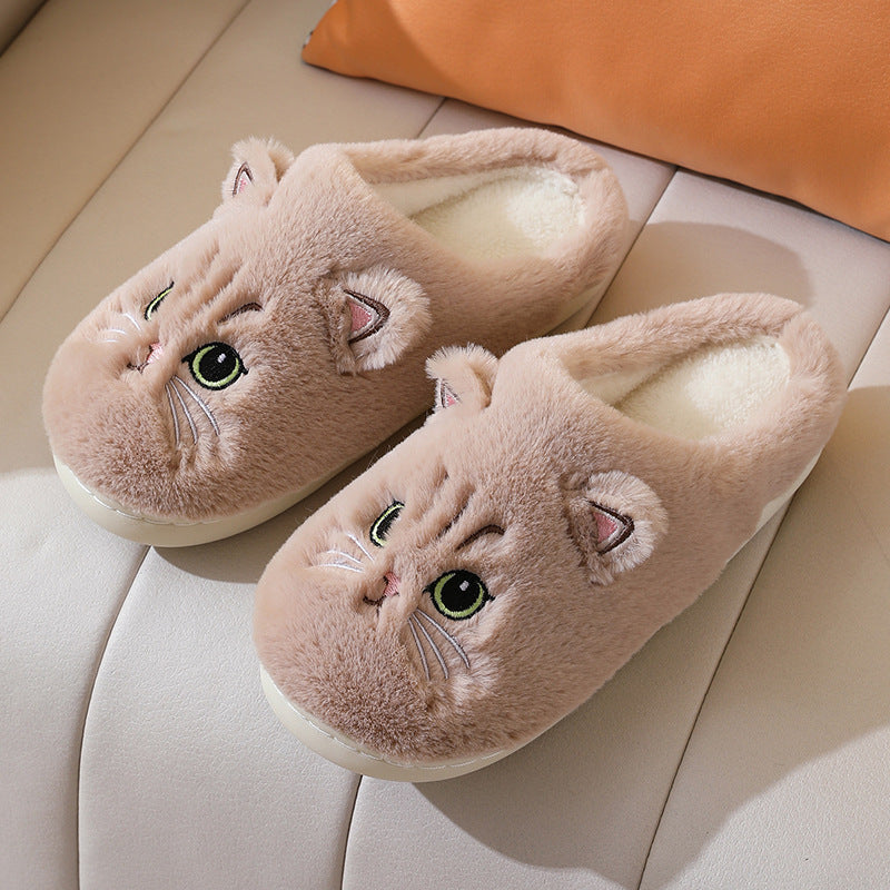 Pair of cat-shaped slippers on a light-colored surface